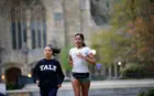 Two students running on the Yale campus