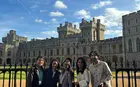 group of five people outside a European castle