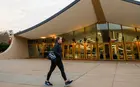 A student walking past a modernist ice rink