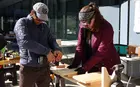 Two people drilling wood