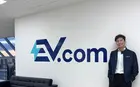Joel Li next to an EV.com sign