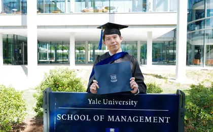 Austin He in front of Yale SOM sign