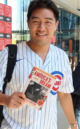 A student holding a book by a Hispanic author