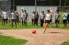 Person kicking a ball during a game with teammates behind them