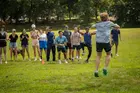 person in a blue shirt jumping while a group of people looks on