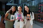 Three women holding books by Hispanic authors
