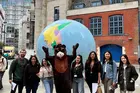 group of friends outdoors in a city with a mascot