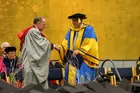 Two men in academic regalia shaking hands