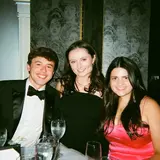 Three people in formal wear sitting at a table