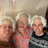 three people wearing wigs to look like Einstein