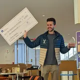 Renato Carregha ’23 holding a giant check 