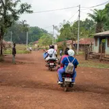 Nurses on motorcycles in a rural village in Sierra Leone