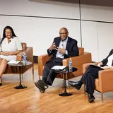 Three panel speakers sitting in chairs and smiling