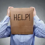 Man with box on head that says help!