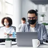 group of people working in an office with masks on h