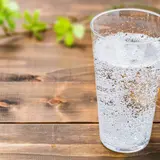 clear glass of seltzer water on wooden background