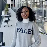 photo of Christiana Opoku in a Yale sweatshirt outside in the Evans Hall courtyard