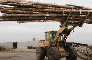 A loader carrying lumber