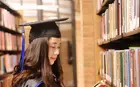 Fang Liu in library holding a book