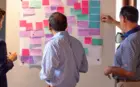 Three people working with an idea board