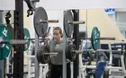 A student lifting weights in a gym