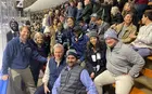 A group of people wearing Yale attire on the bleachers at an ice hockey game