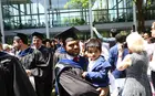 A graduating student holding a child