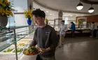 A student selecting food from a lunch buffet