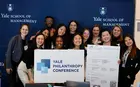 A group of people posing with a sign reading “Yale Philanthropy Conference”