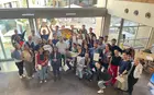 A group of students posing for a photo in the atrium of a building, photographed from above