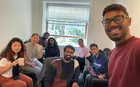 A group of people posing for a selfie inside an apartment