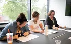 Three women laughing while doing work.