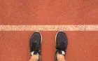 Two feet on a track at the starting line about to walk or run- intrinsic motivations for new years resolutions