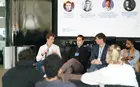Four speakers talking at the front of a lecture hall