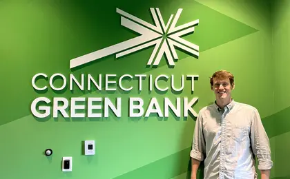 Kevin Moss in front of Connecticut Green Bank sign