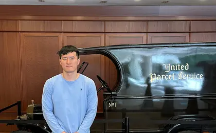 A person standing in front of an antique UPS vehicle