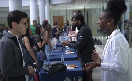 Two people talking, with a low table between them