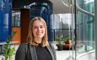 A person wearing a blazer over a black shirt