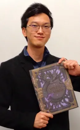 Sam Jiang holding a Wizards employee handbook