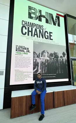 One student in front of screen displaying Black History month content in Evans Hall
