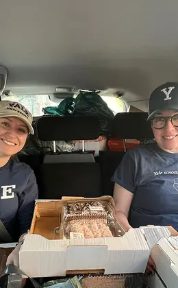 two people in a car surrounded by boxes of food