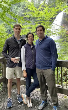 three people in front of a waterfall