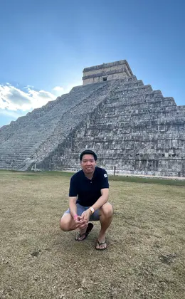 A student posing in front of the ancient Mayan structure Chichén Itzá 