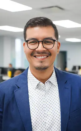 A person wearing a suit jacket smiling