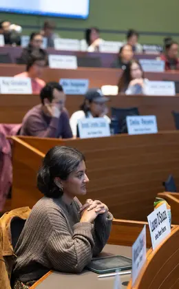 Several students listening to a professor in an auditorium