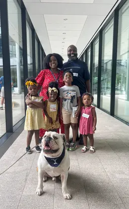 A family posing with a bulldog