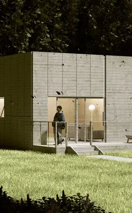 A person standing outside a concrete house built with sustainable materials in the evening