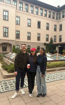 Three people standing in an outdoor courtyard