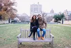 Couple sits on a bench with Yale campus in the background