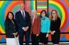 A posed photo of the five Donaldson Fellows in front of colorful artwork